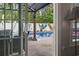 View of the pool from inside the house, showcasing lush green trees and an outdoor seating area at 144 Baylee Circle, Aynor, SC 29544