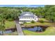 Aerial view of a white clubhouse featuring a pond, surrounded by lush greenery and a wooden bridge at 149 Old Cedar Loop, Pawleys Island, SC 29585