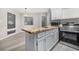 Kitchen island with light herringbone wood countertop, white shaker cabinets, and modern stainless appliances at 1500 Cenith Dr. # B-403, North Myrtle Beach, SC 29582