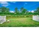 A green backyard with a view of a river and lush trees, framed by a white fence at 153 Goldenrod Circle # 7D, Little River, SC 29566