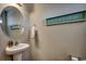 Cozy bathroom with pedestal sink, round mirror, and beach-themed decor at 153 Goldenrod Circle # 7D, Little River, SC 29566