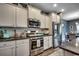 Kitchen with stainless steel appliances, granite countertops, and white cabinetry at 153 Goldenrod Circle # 7D, Little River, SC 29566
