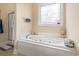 Relaxing bathroom showcasing a luxurious jetted tub and a decorative stained glass window at 165 Northside Dr., Little River, SC 29566