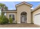 Elegant front entrance with arched doorway and decorative accents, surrounded by lush greenery at 165 Northside Dr., Little River, SC 29566