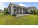 Rear exterior with a screened in porch, patio, lawn, and manicured landscaping at 165 Northside Dr., Little River, SC 29566