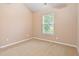 This bedroom includes neutral carpet, a window with a view and a ceiling fan at 1654 Low Country Pl. # C, Myrtle Beach, SC 29577