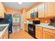 This kitchen features wood cabinets, black appliances, and hardwood floors, offering both style and functionality at 1654 Low Country Pl. # C, Myrtle Beach, SC 29577