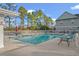 A community pool is flanked by lounge chairs and trees at 1654 Low Country Pl. # C, Myrtle Beach, SC 29577