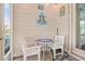 Outdoor seating area with a small table and white chairs and beach themed decor at 1715 Lake Egret Dr., North Myrtle Beach, SC 29582