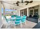Covered patio with ceiling fans and string lights and a turquoise table and chairs at 1715 Lake Egret Dr., North Myrtle Beach, SC 29582