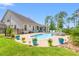 A beautifully landscaped backyard featuring a pool with spa, lounge area, and patio at 1715 Lake Egret Dr., North Myrtle Beach, SC 29582
