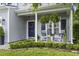 Cozy front porch featuring rocking chairs, hanging ferns, and well-maintained landscaping at 185 Rocko Dr., Myrtle Beach, SC 29579