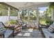 Relaxing screened porch with wicker furniture, ceiling fan and serene backyard views at 185 Rocko Dr., Myrtle Beach, SC 29579