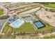 An aerial view of the community pool, tennis court, and surrounding neighborhood construction at 1898 Moonseed Dr., Longs, SC 29568