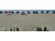 Expansive sandy beach featuring blue umbrellas and chairs for relaxation by the ocean at 201 S Ocean Blvd. # 205, Myrtle Beach, SC 29577