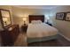 Cozy bedroom with wood-look floors, a queen bed, a dresser, and a nightstand at 201 S Ocean Blvd. # 205, Myrtle Beach, SC 29577