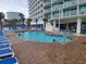Inviting outdoor pool surrounded by lounge chairs and lush landscaping at 201 S Ocean Blvd. # 205, Myrtle Beach, SC 29577