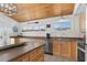Kitchen area with wood ceiling, stainless dishwasher and sink under window offering natural light into the space at 204 55Th Ave. N, North Myrtle Beach, SC 29582