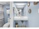 Cozy bathroom featuring a toilet, sink, towel rack, and decorative mirrors on a blue wall at 2300 N Ocean Blvd. # 132, Myrtle Beach, SC 29577