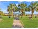 A boardwalk leading to the beach with grassy dunes, palm trees, and blue skies at 2300 N Ocean Blvd. # 132, Myrtle Beach, SC 29577