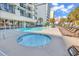 Pool area featuring a hot tub, lounge chairs, palm trees, and hotel at 2300 N Ocean Blvd. # 132, Myrtle Beach, SC 29577