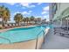 Outdoor pool with beach access, palm trees, lounge chairs, and a clear blue sky above at 2300 N Ocean Blvd. # 132, Myrtle Beach, SC 29577