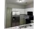 Spacious kitchen featuring a stainless steel refrigerator, black appliances, and ample cabinet storage at 2498 Coastline Ct. # 301, Murrells Inlet, SC 29576