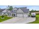 This house features a three-car garage, a well-maintained lawn, and landscaping at 2554 Dogwood Rd., Longs, SC 29568