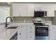 Kitchen boasts stainless steel appliances, white cabinets, quartz countertops, and a black faucet at 2715 Wood Creek Ln., Conway, SC 29527