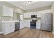 Bright kitchen featuring stainless steel appliances, white cabinets, and wood-look flooring at 2715 Wood Creek Ln., Conway, SC 29527