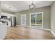 Living and kitchen area featuring stainless steel appliances, white cabinets, wood-look flooring, and backyard access at 2715 Wood Creek Ln., Conway, SC 29527