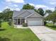 Exterior view of a single-Gathering home with a two-car garage and a well-maintained lawn at 2738 Canvasback Trail, Myrtle Beach, SC 29588