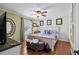 This bedroom offers hardwood floors, soft green walls, a ceiling fan, and plenty of natural light at 280 Morgan Ave., Little River, SC 29566