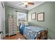 This quaint bedroom has wood paneled walls, a ceiling fan, and a window at 280 Morgan Ave., Little River, SC 29566