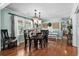 Elegant dining room with hardwood floors, stylish chandelier, and ample natural light from large windows at 280 Morgan Ave., Little River, SC 29566