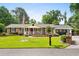 Charming brick home featuring a welcoming front porch and a well-manicured lawn with mature trees at 280 Morgan Ave., Little River, SC 29566