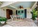 This is a patio with a table and chairs, and bright blue doors and shutters at 280 Morgan Ave., Little River, SC 29566