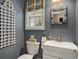 Half bathroom features a window with a colorful awning, a patterned mirror, and textured walls at 280 Oatland Lake Rd., Pawleys Island, SC 29585
