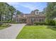 Charming brick home with manicured lawn, paver driveway, and mature trees at 280 Oatland Lake Rd., Pawleys Island, SC 29585