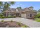 Brick home featuring a paver driveway, manicured landscaping, and a two-car garage at 280 Oatland Lake Rd., Pawleys Island, SC 29585