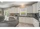 The kitchen has white cabinets, granite countertops and backsplash, stainless steel appliances, and lots of storage space at 280 Oatland Lake Rd., Pawleys Island, SC 29585