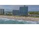 Aerial view of a beachfront property with a sandy beach, crashing waves, and high-rise accommodations at 3000 N Ocean Blvd. # 230, Myrtle Beach, SC 29577