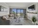 Living room boasts modern decor, a comfortable couch, and a sliding glass door to a balcony with ocean views at 3000 N Ocean Blvd. # 230, Myrtle Beach, SC 29577