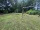 Green backyard with an old wooden swing set and sparse landscaping at 318 Muirfield Rd., Myrtle Beach, SC 29588