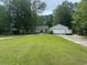 Well-manicured front yard with a lush green lawn, a white brick garage, and a single story home at 318 Muirfield Rd., Myrtle Beach, SC 29588