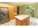 Open kitchen features a center island, stainless steel refrigerator, and a cozy fireplace in the adjacent room at 318 Muirfield Rd., Myrtle Beach, SC 29588
