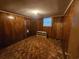 A simple bedroom with carpet, wood paneled walls, and a small window at 331 Dixon St., Mullins, SC 29574