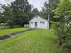 A cozy one-story home with green shutters and lush green lawn and mature trees at 331 Dixon St., Mullins, SC 29574