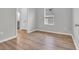 Neutral bedroom with wood-look floors, bright window, and open doorway to a bathroom at 346 High Falls Dr., Conway, SC 29526
