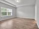 Bright bedroom with wood-look flooring, tray ceiling, a large window and neutral color scheme at 346 High Falls Dr., Conway, SC 29526